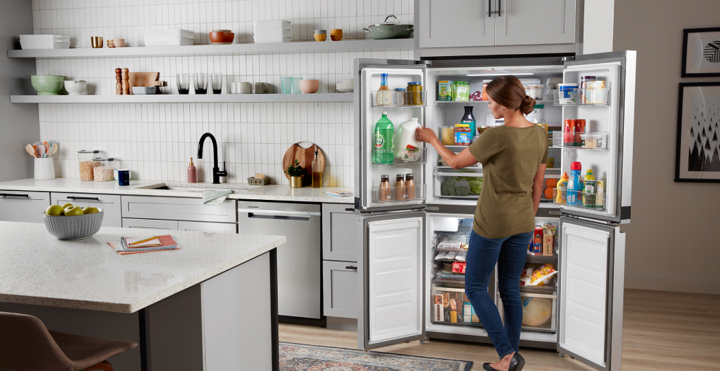 woman putting away groceries into a double french door refrigerator